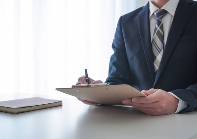 会議でメモを取るビジネスマン