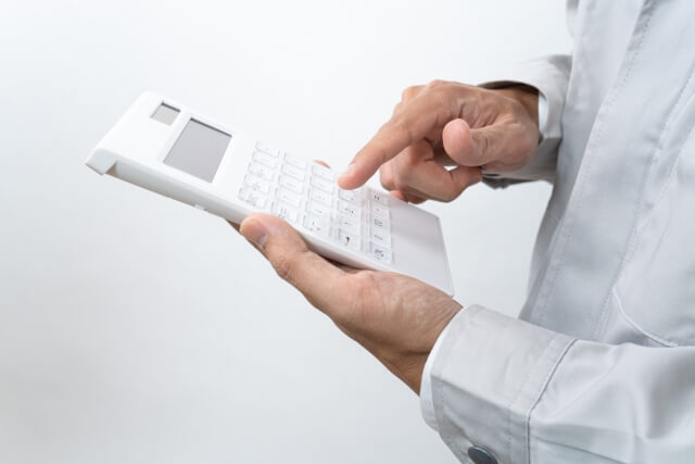 電卓を使うビジネスマンの手元